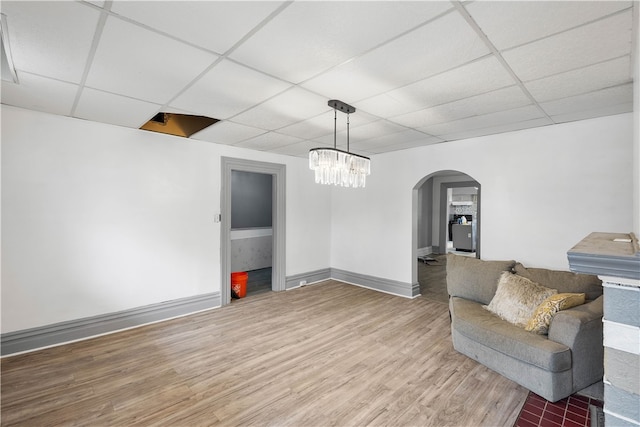 unfurnished room featuring an inviting chandelier, hardwood / wood-style flooring, and a paneled ceiling