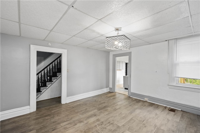 spare room with wood-type flooring and a paneled ceiling