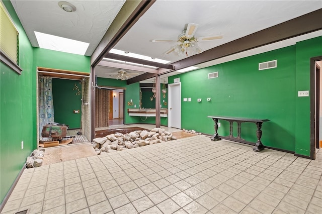 interior space featuring a skylight and ceiling fan