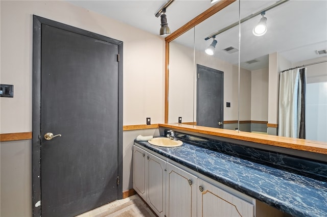 bathroom with rail lighting and large vanity