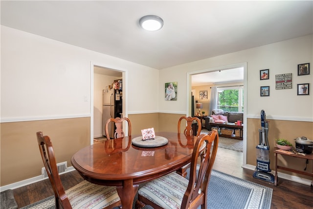 dining space with dark wood-type flooring