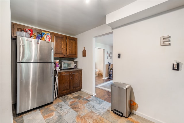 kitchen featuring tile flooring and stainless steel refrigerator