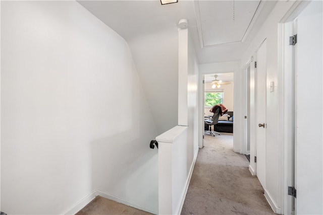 corridor with light colored carpet and lofted ceiling