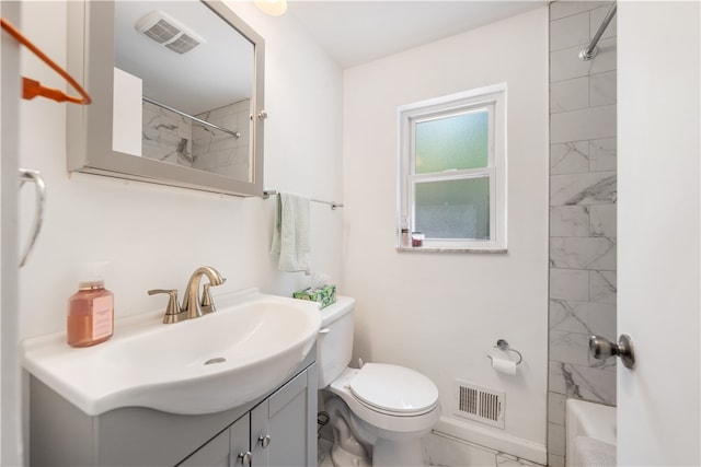 full bathroom with tile floors, vanity, tiled shower / bath combo, and toilet