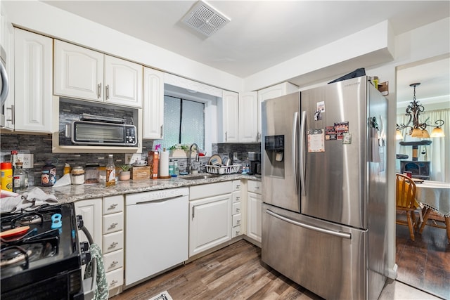 kitchen with sink, white dishwasher, stainless steel refrigerator with ice dispenser, black range, and hardwood / wood-style floors