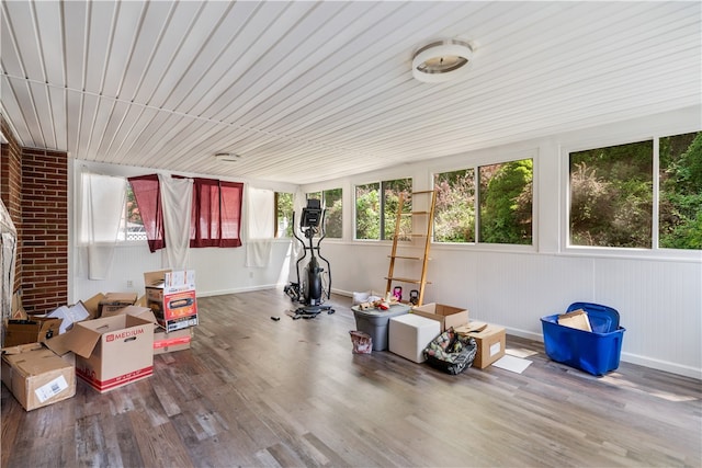 exercise area with hardwood / wood-style floors and brick wall