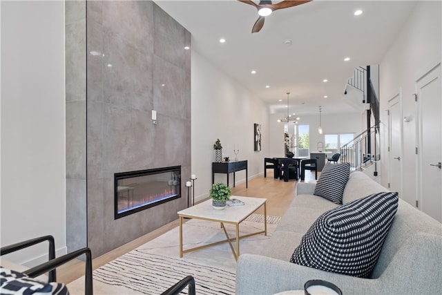 living room featuring a fireplace, hardwood / wood-style floors, and ceiling fan