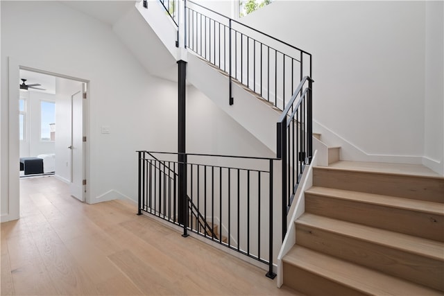 stairs with light hardwood / wood-style flooring, ceiling fan, and plenty of natural light