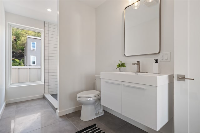 bathroom with walk in shower, toilet, tile flooring, and vanity