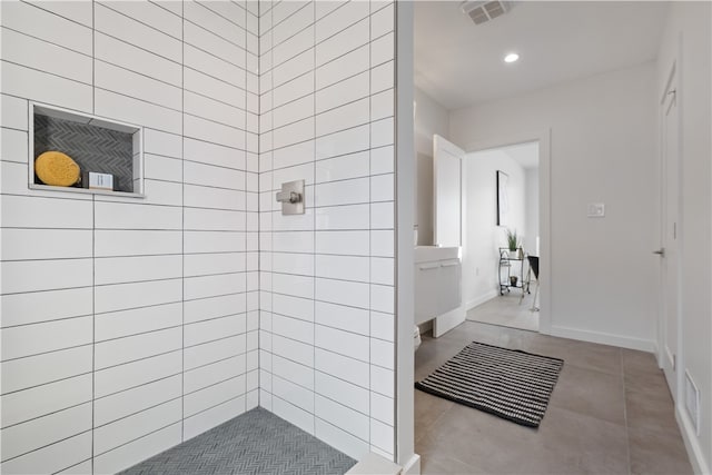 bathroom featuring tile flooring and a tile shower