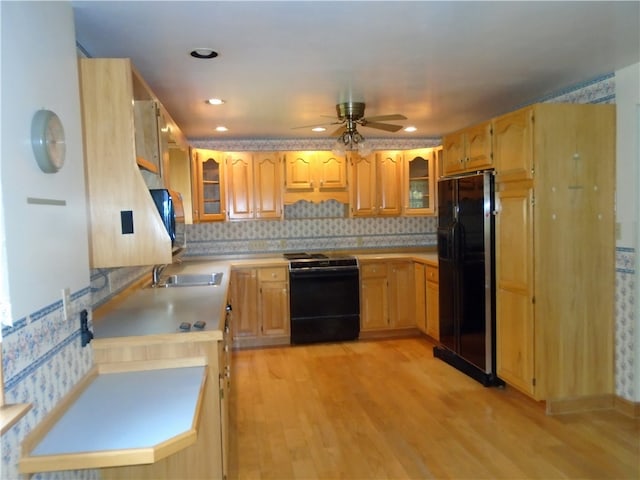 kitchen featuring range with electric cooktop, black fridge, backsplash, ceiling fan, and light wood-type flooring