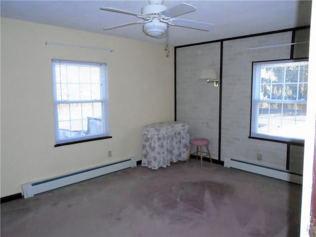 carpeted empty room featuring plenty of natural light, ceiling fan, and a baseboard radiator