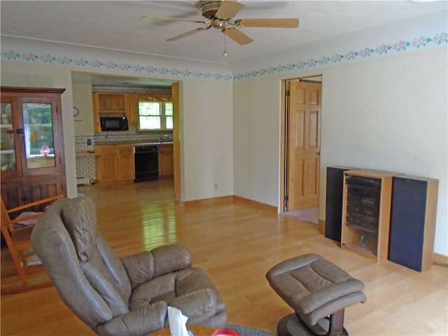 living room with light hardwood / wood-style flooring and ceiling fan