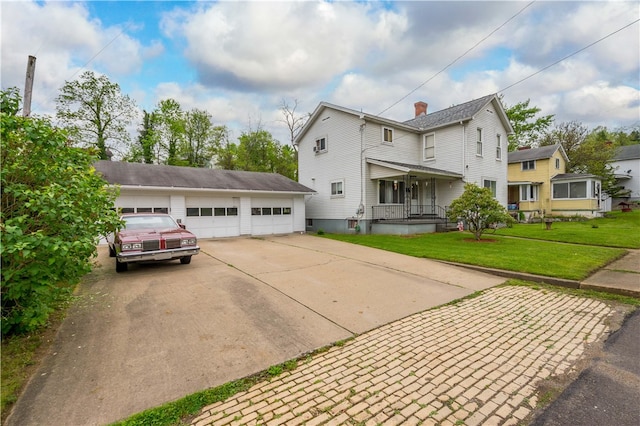 view of front of house featuring covered porch, a garage, and a front lawn