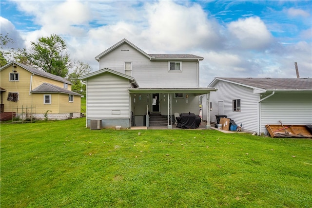 back of property featuring a yard and central AC