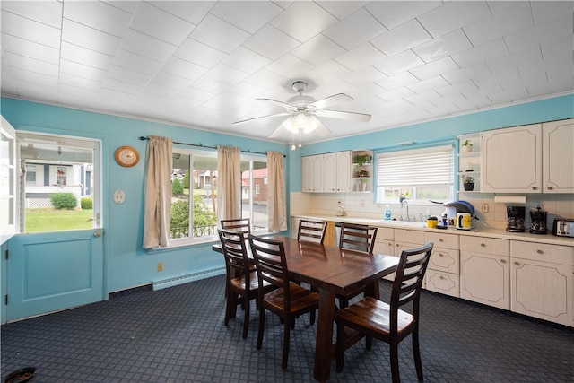 dining area featuring sink, ceiling fan, and baseboard heating