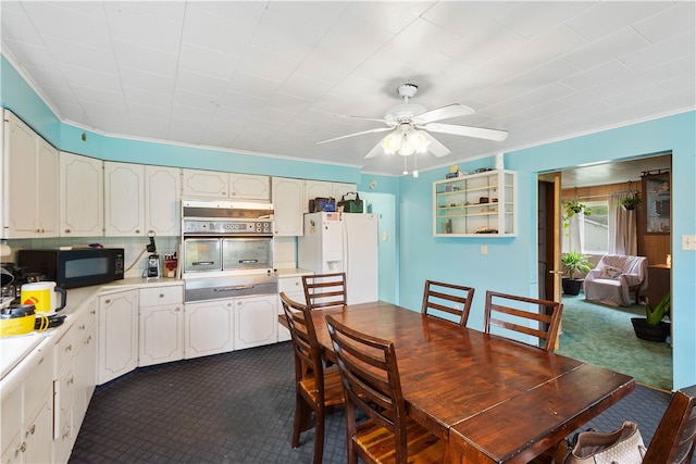 dining area featuring ornamental molding, ceiling fan, and dark carpet