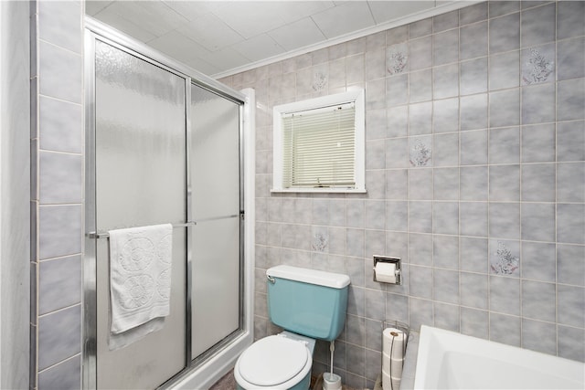 bathroom with tile walls, an enclosed shower, and toilet