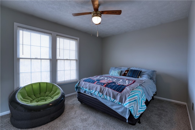 carpeted bedroom with ceiling fan and a textured ceiling