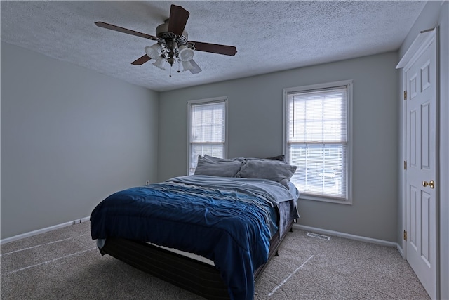 carpeted bedroom with a textured ceiling and ceiling fan