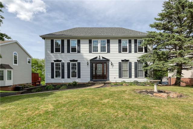 colonial house with a front yard and central AC