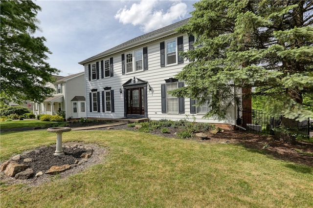 colonial home featuring a front lawn