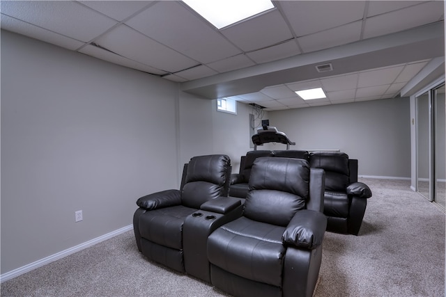 cinema with a paneled ceiling and carpet