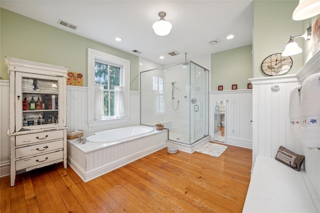 bathroom with shower with separate bathtub and hardwood / wood-style floors