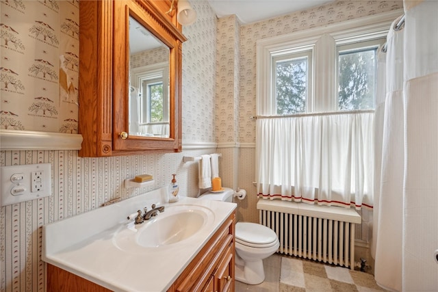 bathroom featuring vanity with extensive cabinet space, tile flooring, toilet, and radiator