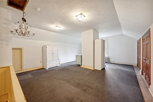 interior space featuring vaulted ceiling, a textured ceiling, a chandelier, and radiator