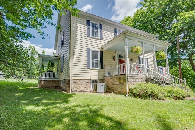 view of front of home featuring a front yard, central air condition unit, and a porch