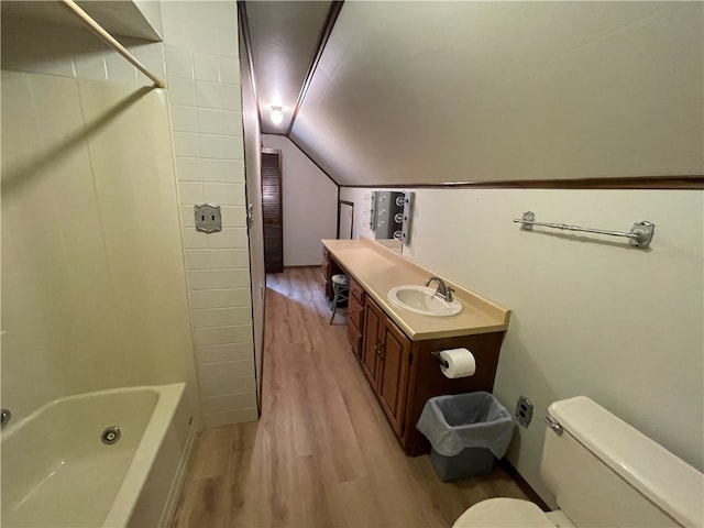 full bathroom featuring toilet, tub / shower combination, vanity, hardwood / wood-style flooring, and lofted ceiling