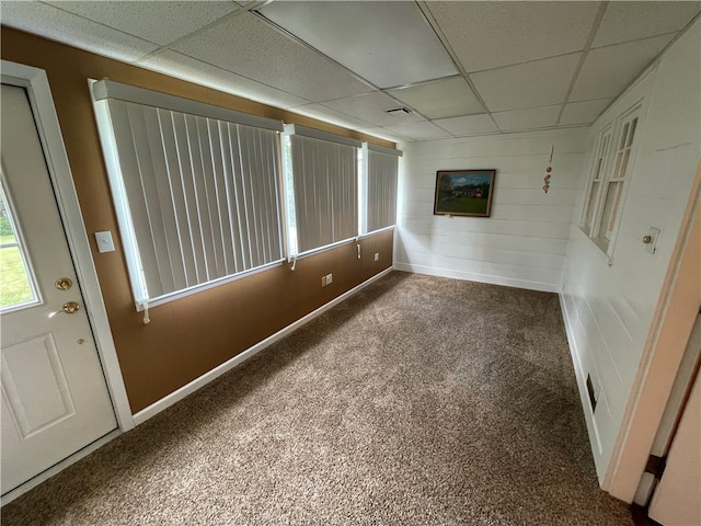 interior space featuring a drop ceiling and dark carpet