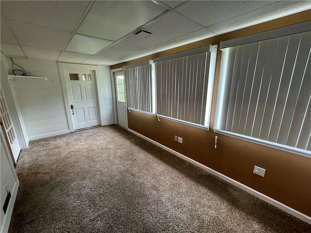 empty room with carpet flooring and a drop ceiling