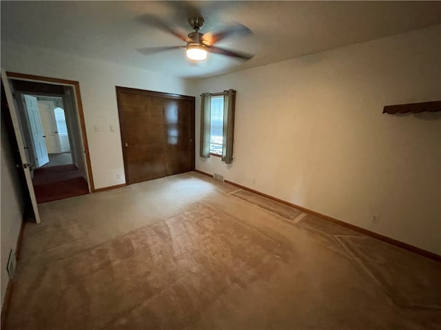 unfurnished bedroom featuring carpet flooring, ceiling fan, and a closet