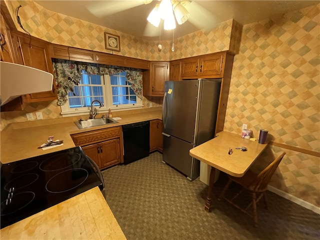 kitchen featuring sink, dishwasher, stove, stainless steel fridge, and exhaust hood