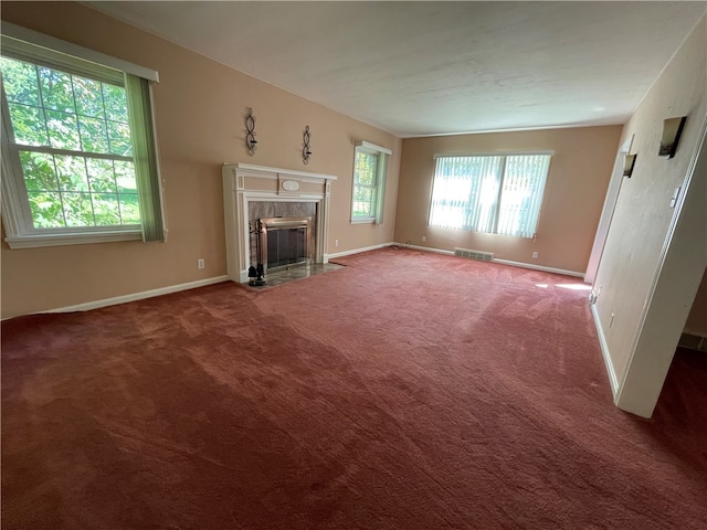 unfurnished living room with a premium fireplace and carpet flooring