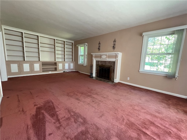 unfurnished living room with a fireplace and dark carpet