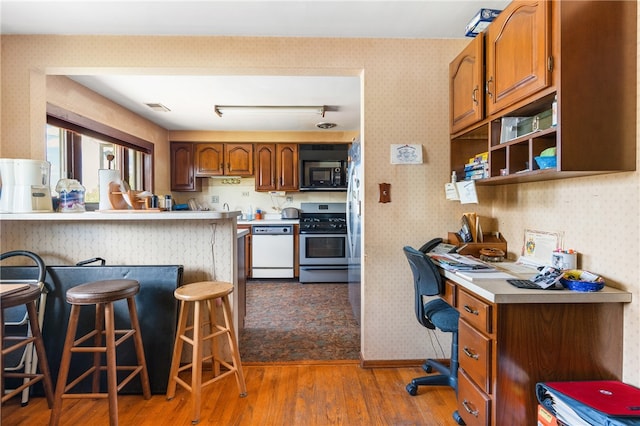 kitchen with stainless steel range, dishwasher, a breakfast bar, and tile flooring