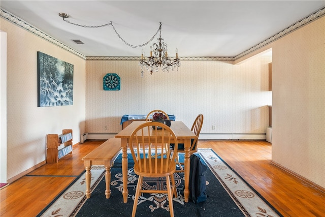 dining room featuring an inviting chandelier, a baseboard radiator, and hardwood / wood-style floors