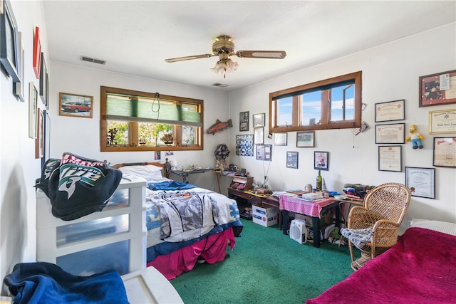 bedroom with multiple windows, ceiling fan, and carpet floors