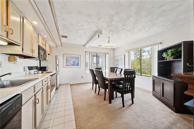 kitchen featuring light brown cabinets, light carpet, sink, hanging light fixtures, and black appliances