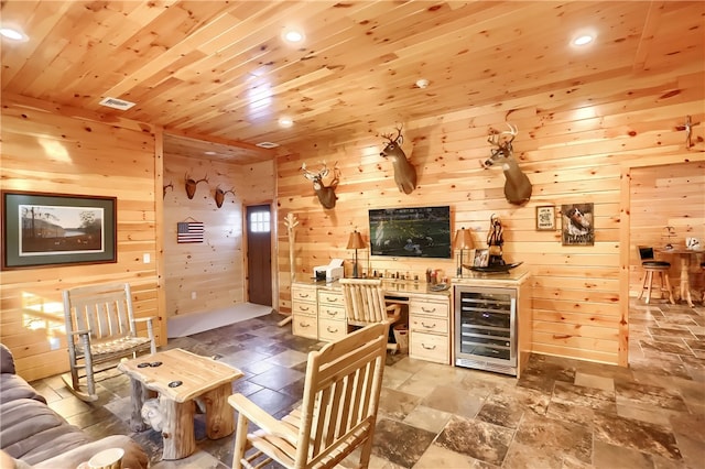 tiled living room featuring wood ceiling, wooden walls, and beverage cooler