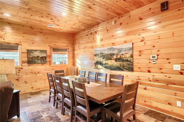 tiled dining area with wooden ceiling and wooden walls