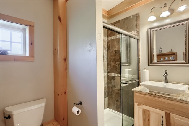 bathroom with ornamental molding, vanity, toilet, and a shower with shower door