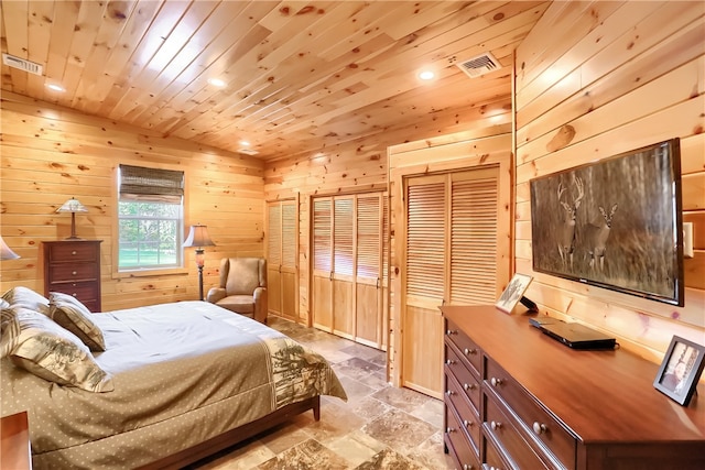 tiled bedroom with wooden walls, wooden ceiling, and multiple closets