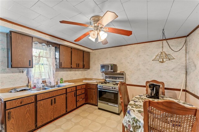 kitchen featuring ceiling fan, crown molding, light tile flooring, sink, and gas range