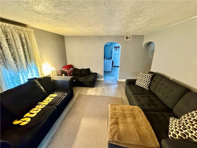 living room with wood-type flooring and a textured ceiling