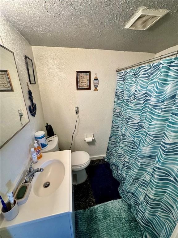 bathroom with vanity, a textured ceiling, and toilet