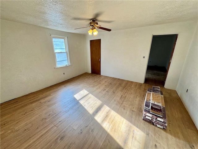 unfurnished room featuring ceiling fan, light hardwood / wood-style floors, and a textured ceiling